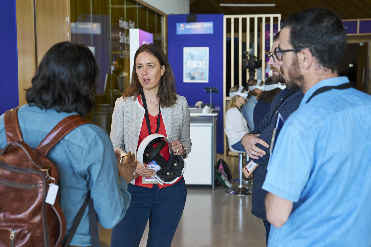 Exposante présentant un casque de réalité virtuelle à des visiteurs